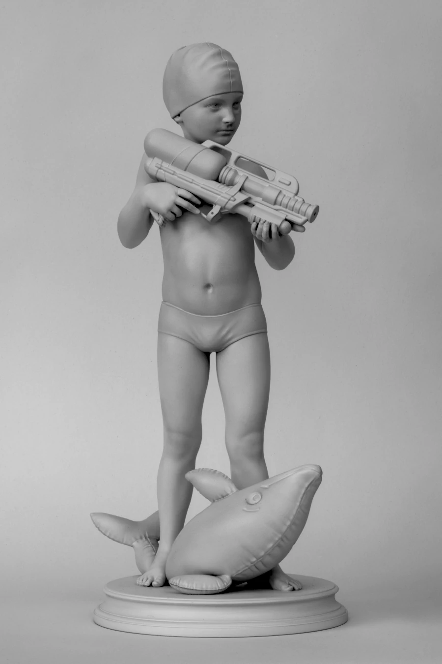Switch, 2024 Switch, 2024. Monochrome sculpture of a child holding a water gun while standing on an inflatable dolphin.